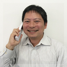 写真：社長が電話をしながら微笑んでいる